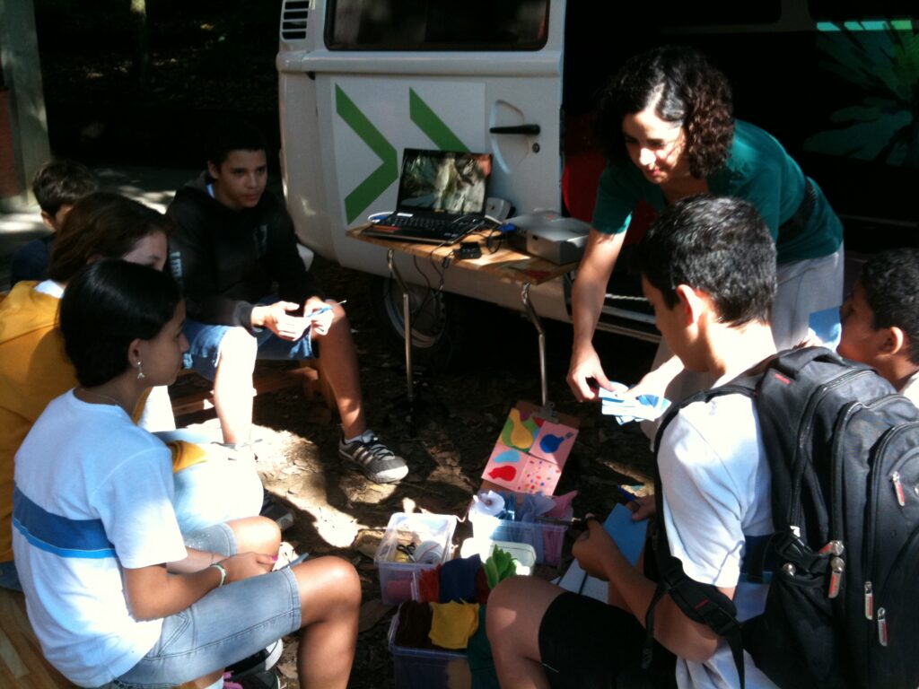 Rachel and Silvia with children participating in a workshop around the EME van in Niteroi, Brazil